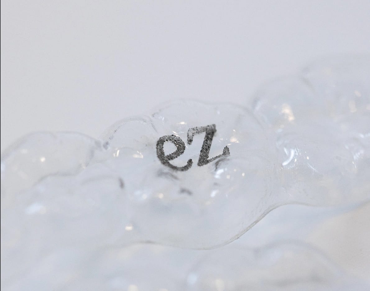 Logotipo ez sobre superfície translúcida de alinhador dental