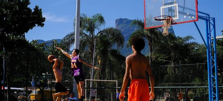 Dois jovens jogando basquete em quadra ao ar livre